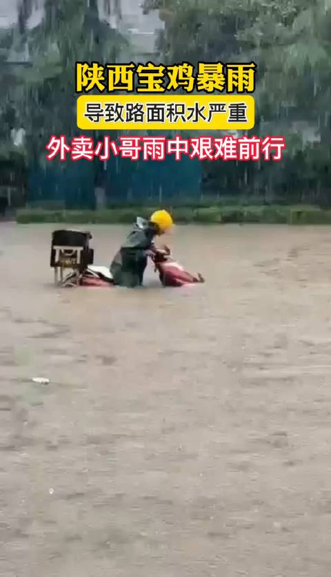 7月27日，陕西宝鸡暴雨，路面积水严重，外卖小哥雨中艰难前行